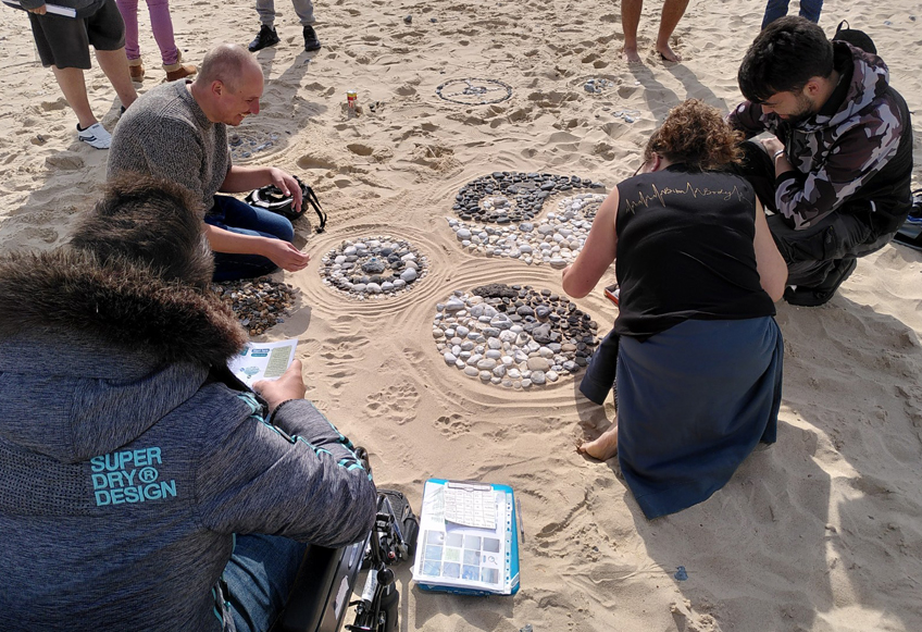 People making stone circles in the sand