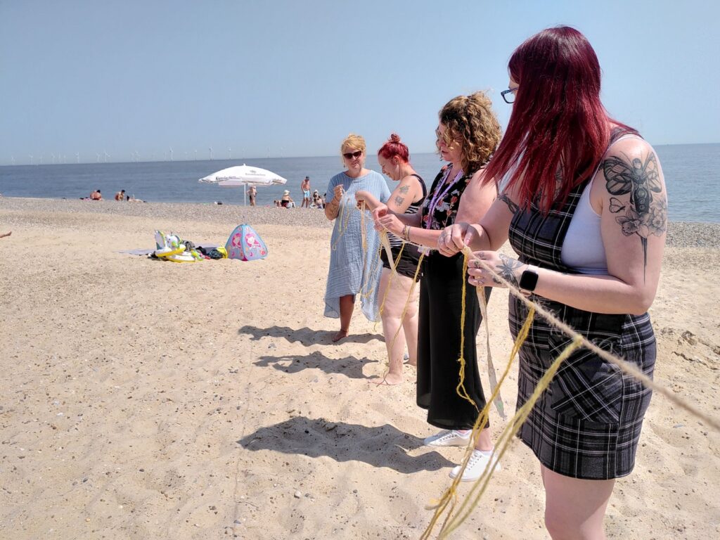 Women working with string on the beach